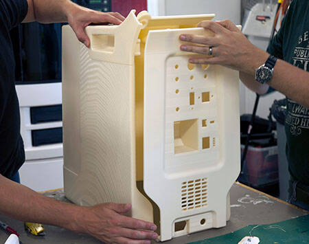 Three hands assembling the SLA prints of an intra-aortic balloon puump cart